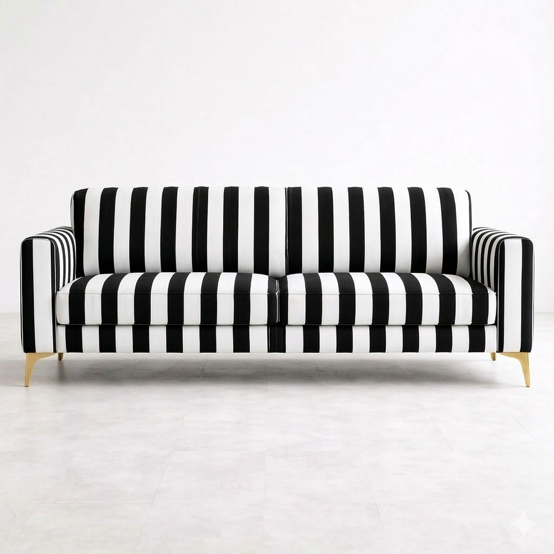 Clear front view of a black and white vertical striped fabric sofa with polished gold legs on a light grey tiled floor.